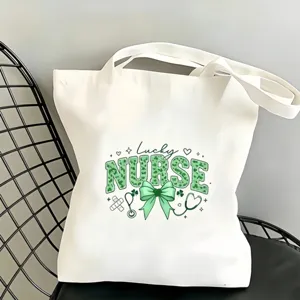 Sac cabas en toile blanche vue de detail avec noeud vert et motif infirmier pour tous les jours.