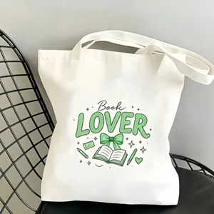 Sac cabas en toile blanche avec un imprimé de livre vert, fourre-tout pratique.