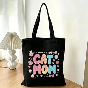 Dettaglio della borsa shopper in tela nera con stampa colorata Cat Mom e zampe.