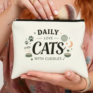 Primer plano detallado de bolsa cosmetica de lona blanca con letras de gatos y brocha.