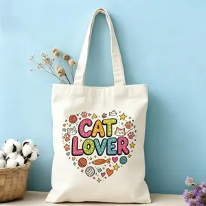 Vue rapprochée du sac cabas en toile écru avec un joli imprimé coloré de cœur d'amoureux des chats.