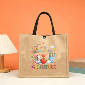 Jute tote bag featuring teacher gratitude print, stylish black handles, durable daily shopper.