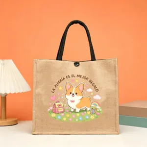 Detail shot of jute tote bag featuring cute corgi graphic and warm Spanish blessing text print.