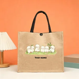 Detailed view of custom jute tote bag featuring cute sheep illustration and black handles.