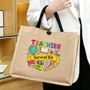 Detail view of teacher theme jute tote bag with colorful print and sturdy black handles.