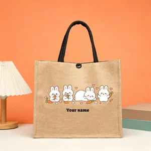 Close-up detail of cute rabbit and carrot pattern printed on the natural jute tote bag.