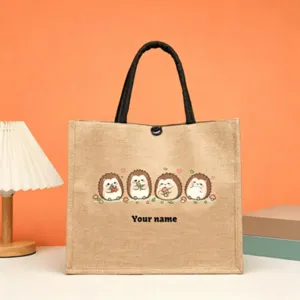 Close-up of customizable jute tote bag with cute cartoon hedgehog print and black handles.