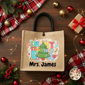 Detailed shot of custom burlap tote bag with Christmas tree print and teacher name.