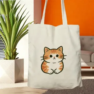 Primo piano della borsa di tela con una simpatica stampa di gatto arancione in un ambiente accogliente.