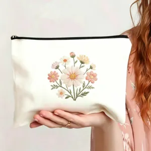 Weißer Kosmetikbeutel aus Segeltuch mit zartem besticktem Blumenbukett, Reißverschlusstasche.