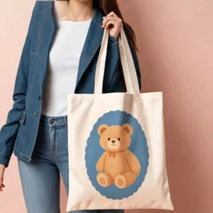 Close-up view of the cute teddy bear print detail on the canvas tote bag fabric texture.