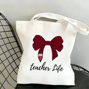 Primo piano della borsa shopper in tela bianca con grazioso motivo a matita teacher life.