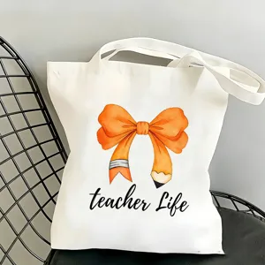 Vista dettagliata della borsa di tela bianca con stampa di fiocco arancione per insegnanti.