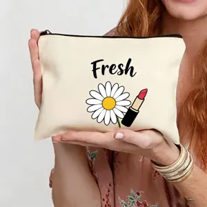 Gros plan sur la trousse de toilette en toile avec imprimé marguerite et rouge à lèvres.