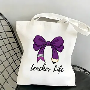 Vista dettagliata della borsa in tela bianca con fiocco a matita viola e stampa scritta teacher.