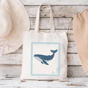 Detailansicht der Segeltuchtasche mit blauem Walmotiv und rustikalem Strandhintergrund.