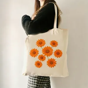 Stilvolle Canvas-Tasche mit orangem Gänseblümchen-Print, ideal für Alltag und Strand.