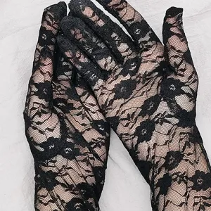 Close-up detail of black lace gloves featuring delicate floral mesh design for elegant wear.