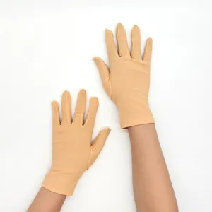 Detail shot of women's short stretch milk silk gloves in flesh tone, smooth and snug fit.