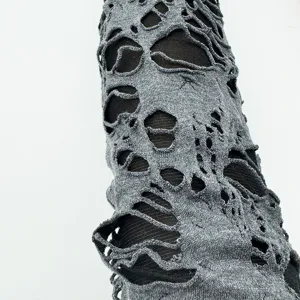 Détail de manche en tricot gris élimé, accessoire de costume Halloween style punk.