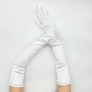 Dettaglio di guanti lunghi in satin bianco con delicati polsini di perle per feste in costume.