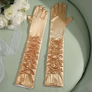 Detailed close-up of long satin pleated gloves in gold, elegant evening wear accessory.
