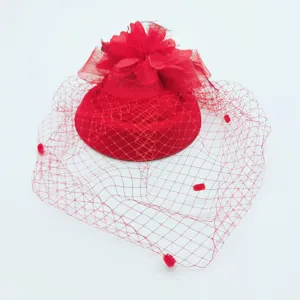 Red vintage fascinator hat detail view, mesh veil with dots and feather floral decoration.