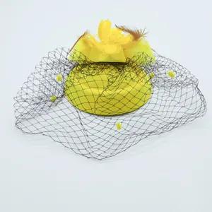 Close-up detail of yellow vintage fascinator hat with black mesh netting and feather decor.