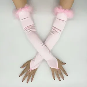 Detail shot of pink satin long gloves featuring fluffy faux fur cuffs and finger loop design.