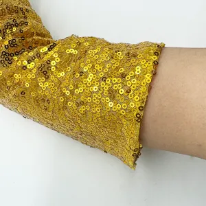 Close-up detail shot of shiny gold sequin long sleeve glove for stage performance.