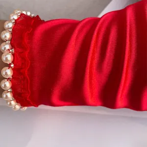 Red stretch satin gloves featuring elegant pearl beads and lace ruffle trim for events.