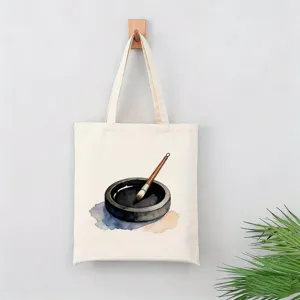 Detalle de bolso de lona con diseño artístico de pincel de tinta y tintero en acuarela.