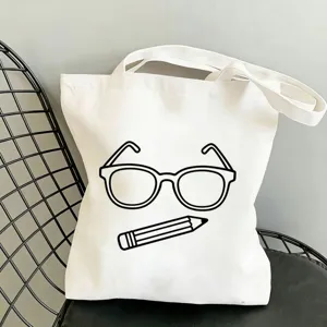 Detailaufnahme einer weißen Stofftasche mit niedlichem Brillen und Stift Motivprint.