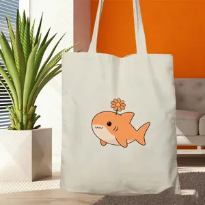 Nahaufnahme der Stofftasche mit dem süßen orangen Haifisch-Druck in einer gemütlichen Umgebung.