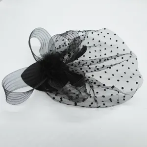 Close-up detail of black vintage mesh fascinator with polka dots and delicate feathers.