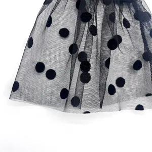 Black polka dot tulle mesh fabric detail, perfect for party sleeves and fashion accessories.