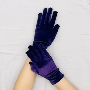 Detail view of dark purple velvet short gloves, elastic fabric, ideal for party wear.