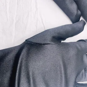 Close-up detail view of black satin elastic gloves, showing smooth fabric texture and fine stitching.