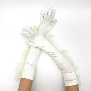 Detailed shot of vintage 1920s white satin long gloves with delicate ruffled lace trim.