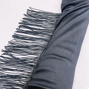 Nahaufnahme Detail von schwarzen Satin Langhandschuhen mit eleganten Fransen für Party.
