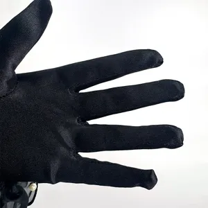 Black satin opera gloves detail shot, 1920s vintage retro style with pearl decor.