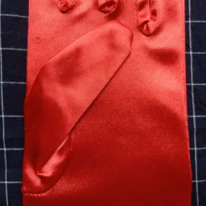 Gants longs en satin rouge vue détaillée, texture de tissu lisse pour gros plan de soirée.