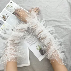 Guanti lunghi trasparenti in tulle con pois e volant per un look da sposa vintage.