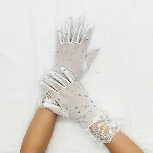 Gros plan de gants en dentelle blanche transparente ornés de strass étincelants.