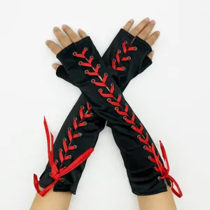 Vue détaillée de mitaines noires ornées d'un design de laçage en ruban rouge contrasté.