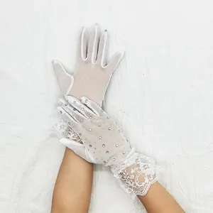 Vue détaillée de gants en dentelle blanche ornés de strass étincelants et fins poignets.