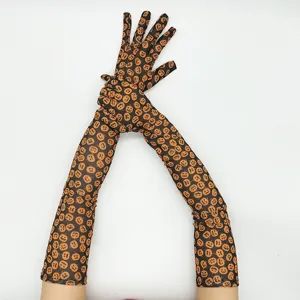 Long black mesh gloves featuring cute orange pumpkin prints, perfect for Halloween party costumes.
