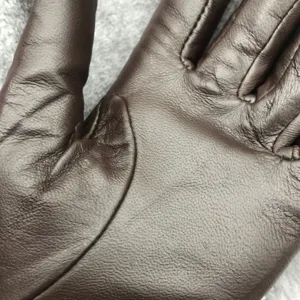 Brown leather winter gloves detail shot, warm sheepskin tactile finger design for women.