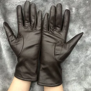 Detail view of brown women winter leather touchscreen gloves, warm split-finger riding wear.