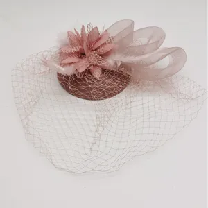 Detailed close-up of pink 1920s fascinator veil featuring delicate mesh, feathers and fabric flower.